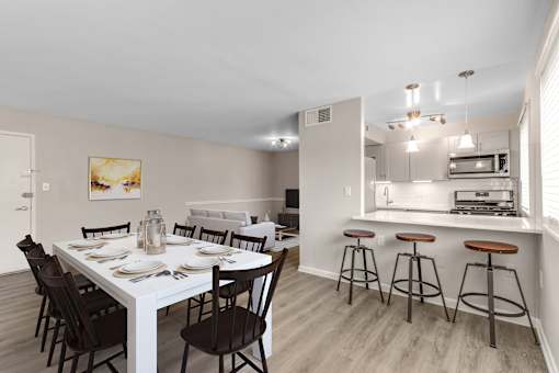 A dining room with a white table and chairs.