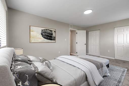 A bedroom with a large bed and a painting on the wall.