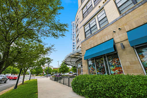 A sidewalk runs alongside a building with a blue awning.