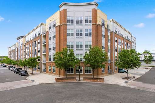 A large multi-story building with a parking lot in front.