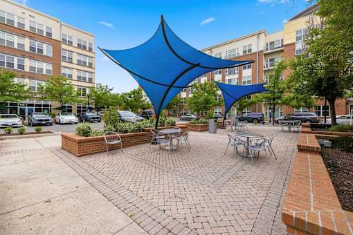 A blue shade structure is in the middle of a courtyard.