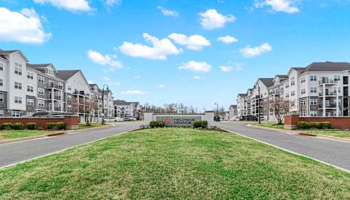 A row of apartment buildings with a grassy area in the foreground.