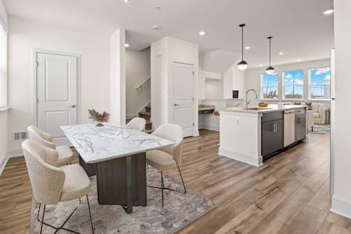 A modern kitchen with a dining table and chairs.