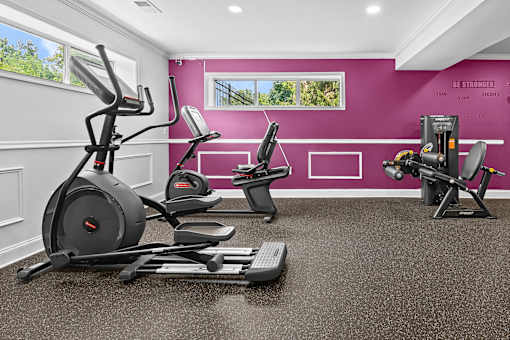 A home gym with a purple wall and exercise equipment.