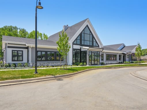 a view of the front of a building with a driveway and a street light