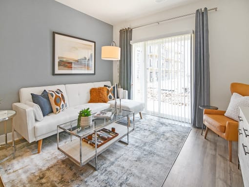 a living room with a white couch and a glass coffee table
