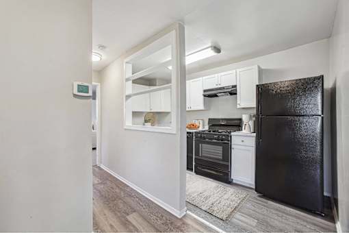 a renovated kitchen with black appliances and white cabinets