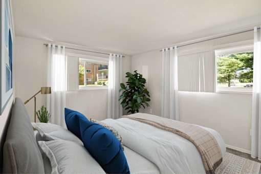 a bedroom with a bed and two windows and a plant