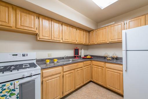 A kitchen with wooden cabinets and a white refrigerator.
