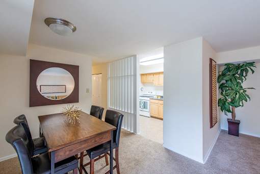 A dining room with a wooden table and chairs.