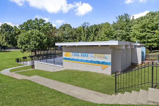 A pool building with the words "This Way to the Pool" on it.