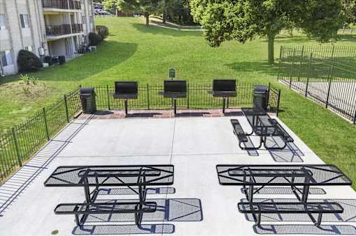 A black metal table and chairs are set up on a concrete patio.