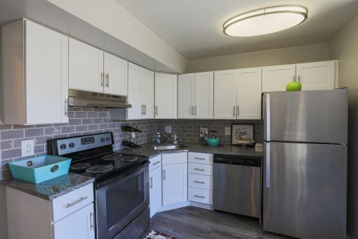 a kitchen with stainless steel appliances and white cabinets