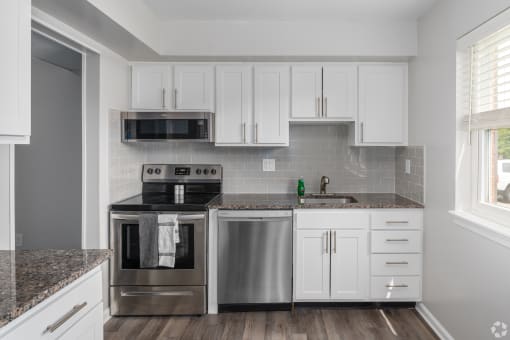 a kitchen with white cabinets and stainless steel appliances