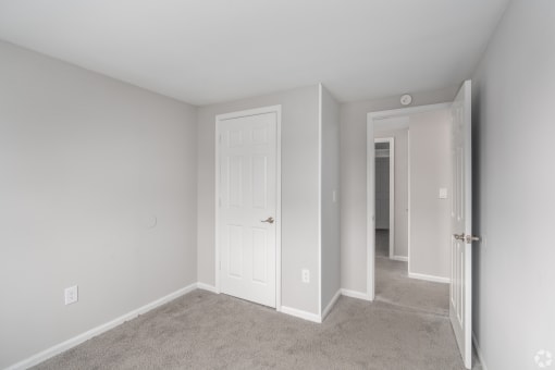 a bedroom with a white door and a closet
