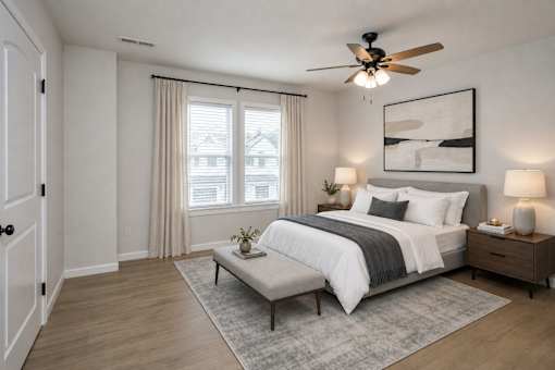 A bedroom with a large bed, a ceiling fan, and a window with curtains.