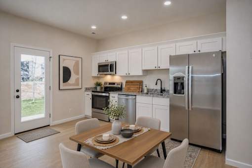 A modern kitchen with a dining table set for two.