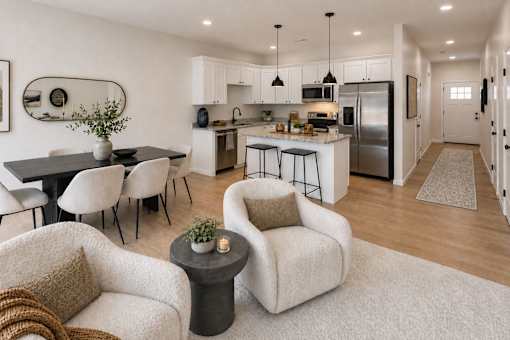 A modern kitchen with white cabinets and a black refrigerator.