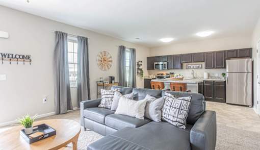 A living room with a grey couch and a wooden coffee table.