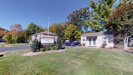 a white building with a sign on the side of a lawn