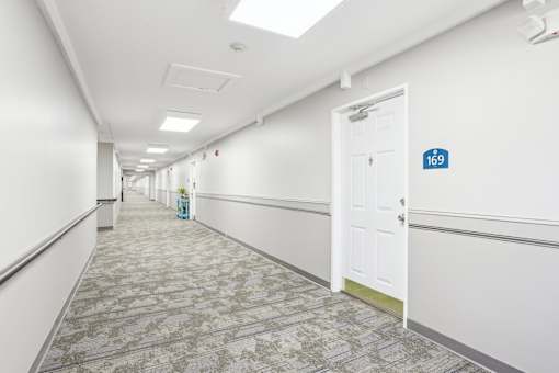 A hallway with a door on the right and a sign on the wall.