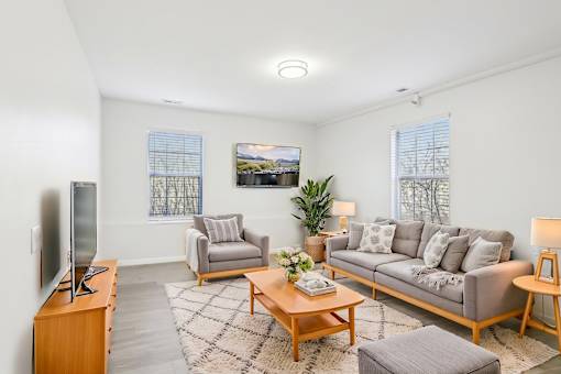 A living room with a grey couch, a wooden coffee table, and a television on a wooden cabinet.