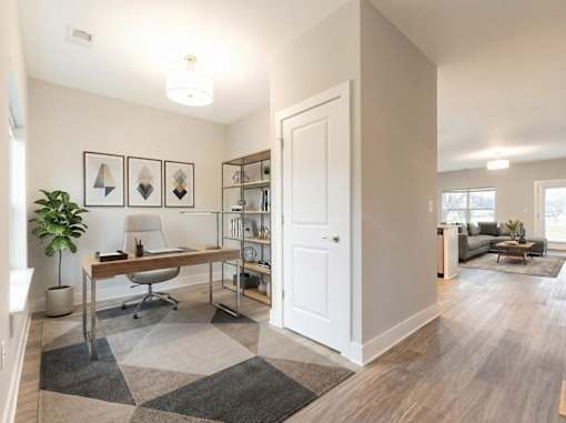 A room with a desk and a chair in it.