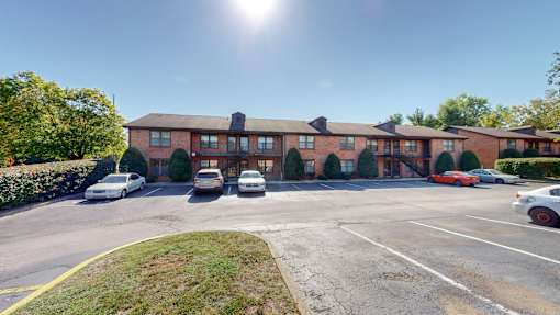 an empty parking lot in front of an apartment building