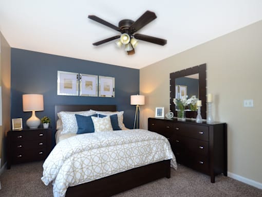 a bedroom with a bed and a ceiling fan