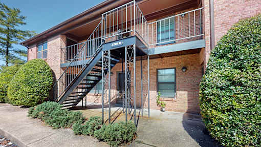 an apartment building with stairs and a balcony
