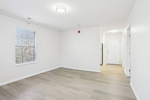A room with a window and a fire extinguisher on the wall.