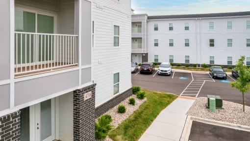 an apartment building with cars parked in a parking lot