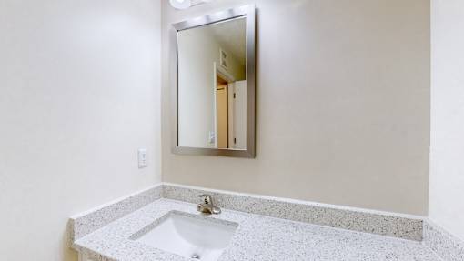 A bathroom with a sink and a mirror.