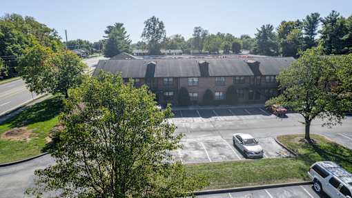 an aerial view of a building with cars parked in a parking lot