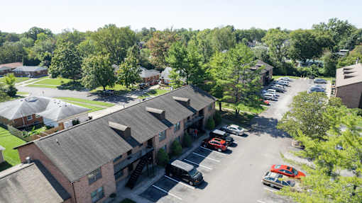 an aerial view of a building with cars parked in a parking lot