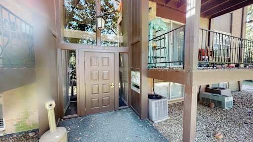 the front door of a house with stairs and a porch