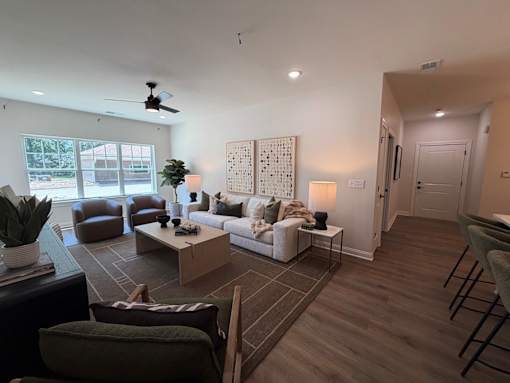 A living room with a brown rug and a white couch.