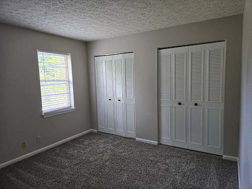 a bedroom with two closets and a window