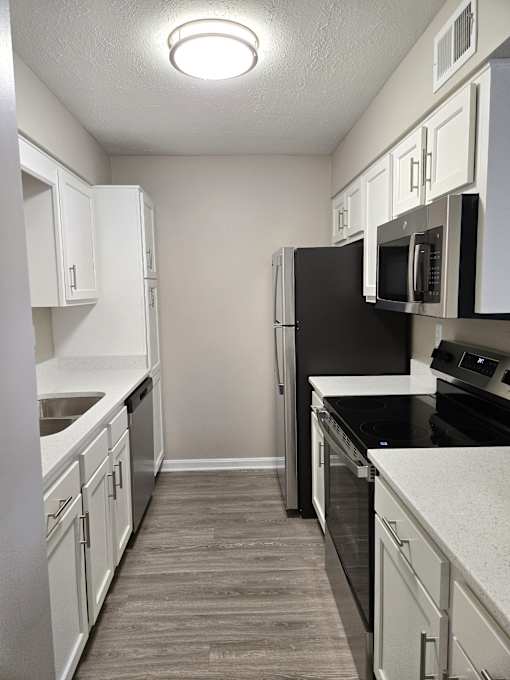 A kitchen with black appliances and white cabinets.