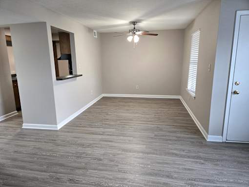 A room with a ceiling fan and a door.