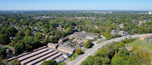 an aerial view of a city with a highway and trees