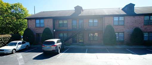 a large brick building with cars parked in front of it