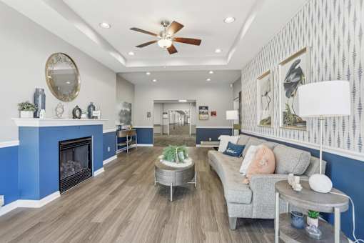 A living room with a grey couch and a blue fireplace.