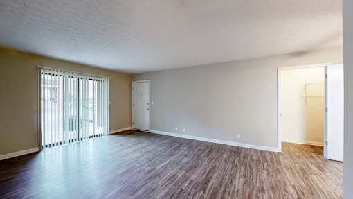 Empty room with wooden flooring and white walls.