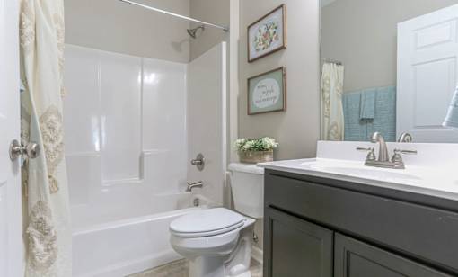 A white toilet is in a bathroom with a white door and a white sink.
