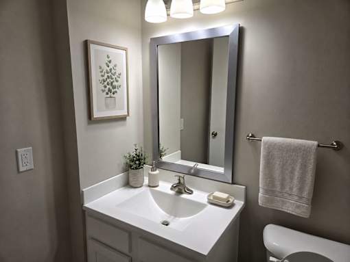 A bathroom with a white sink and a mirror above it.