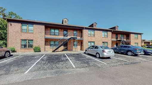 a large brick building with cars parked in a parking lot