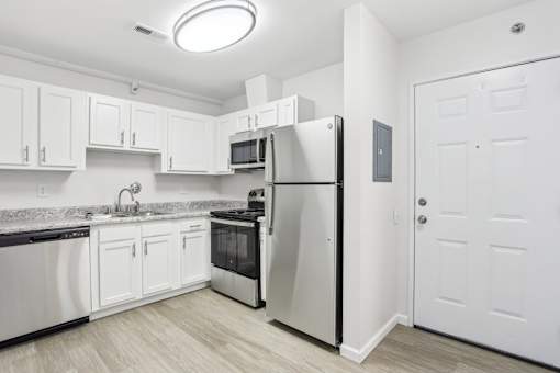 A kitchen with white cabinets and appliances.