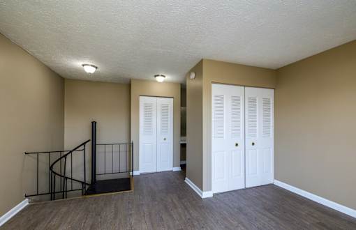 A room with a staircase and two doors.