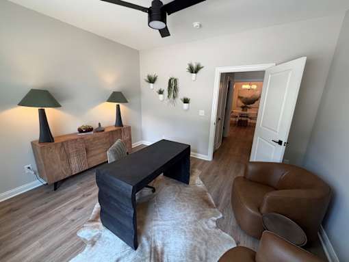 A living room with a black table and brown leather chair.